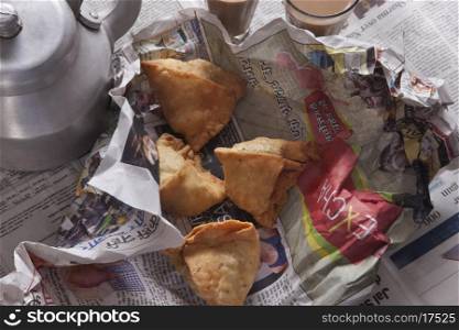 Directly above shot of fresh samosas and tea kettle on table