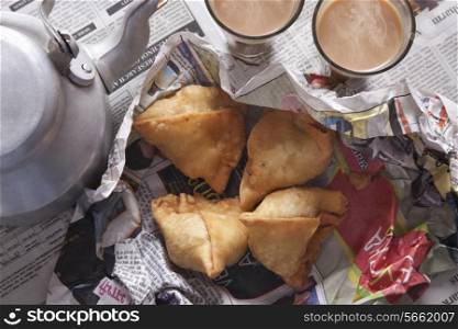 Directly above shot of fresh samosas, tea and kettle on table