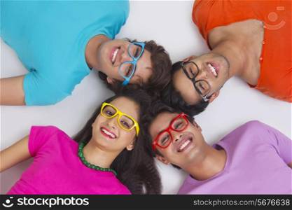 Directly above shot of friends lying with their heads together on white background