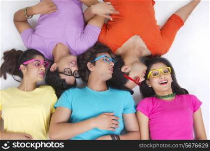 Directly above shot of friends sharing secret while lying over white background