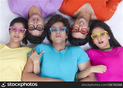 Directly above shot of surprise friends lying over white background