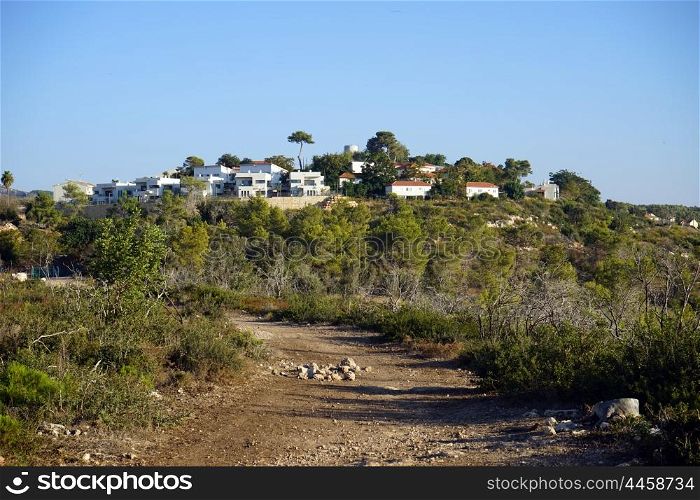Dirt road and village on the hill in Israel