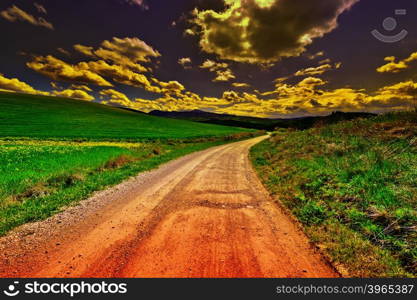 Dirt Road Leading to the Farmhouse in Tuscany, Italy at Sunset