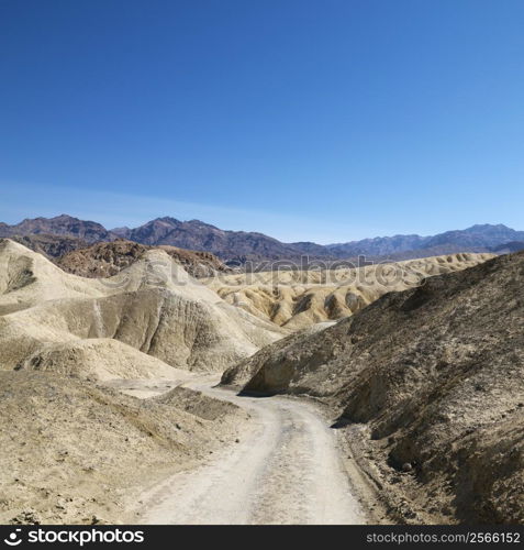 Dirt road through barren landscape in Death Valley National Park.