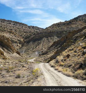 Dirt road winding through rocky desert cliffs of Cottonwood Canyon, Utah.