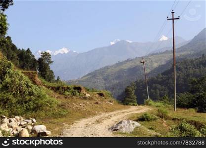 Dirt road with posts and mountain in Nepal