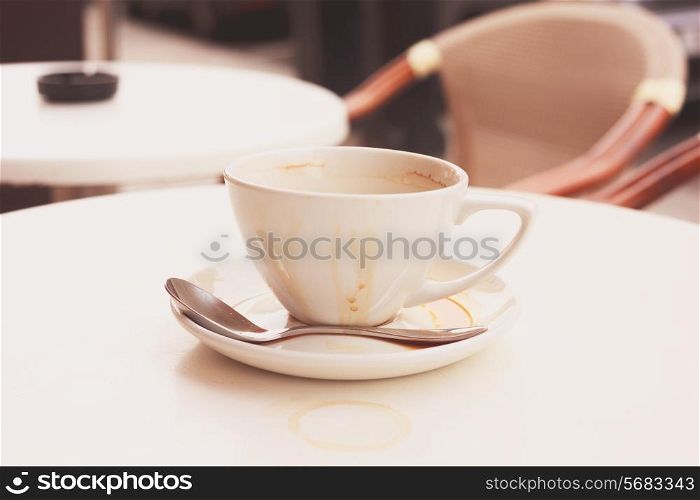 Dirty coffee cup and saucer at a cafe outside on a table