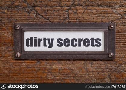 dirty secrets - file cabinet label, bronze holder against grunge and scratched wood