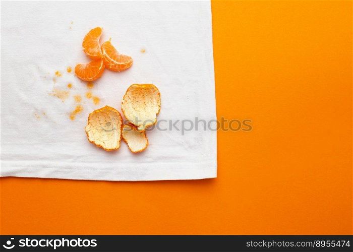 dirty stains on white clothes from fruits mandarin on orange background.. dirty stains on white clothes from fruits mandarin on orange background