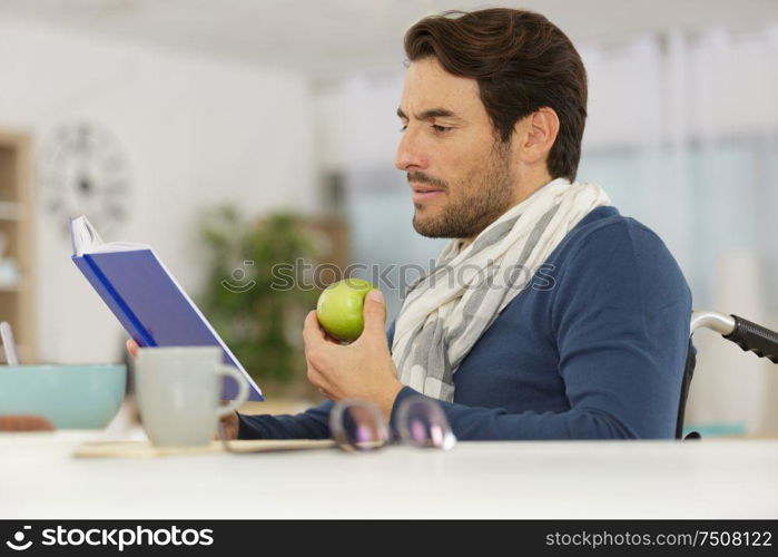 disable man reading a book while eating an apple