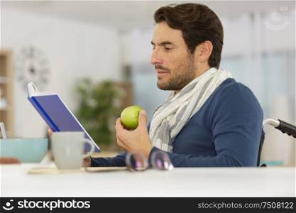 disable man reading a book while eating an apple