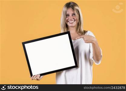 disable young blonde woman pointing finger empty white picture frame