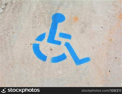 Disabled blue parking sign painted on asphalt.