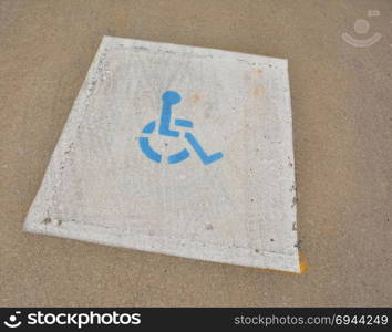 Disabled blue parking sign painted on asphalt.