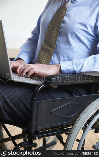 Disabled Businessman In Wheelchair Using Laptop