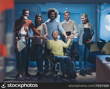 Disabled businesswoman in a wheelchair at the office with coworkers. Portrait of a diverse business team in a modern open space coworking office space. High quality photo. Disabled businesswoman in a wheelchair at the office with coworkers team