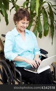 Disabled businesswoman using a tiny netbook computer.