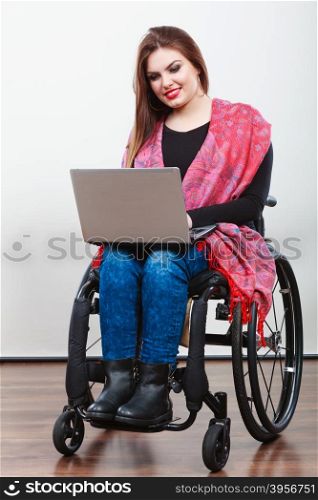 Disabled lady surfing on web. . Disabled lady surfing on web. Young female on wheelchair using laptop. Internet technology education disability concept.