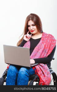 Disabled lady surfing on web. . Disabled lady surfing on web. Young female on wheelchair using laptop. Internet technology education disability concept.