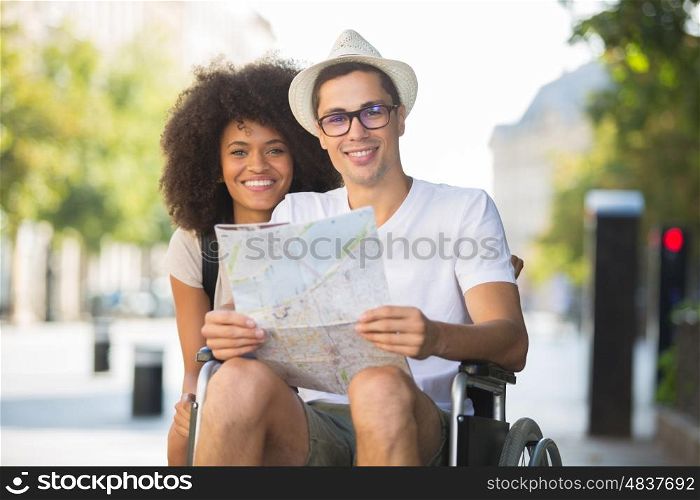 disabled man and girlfriend tourists consulting map of city