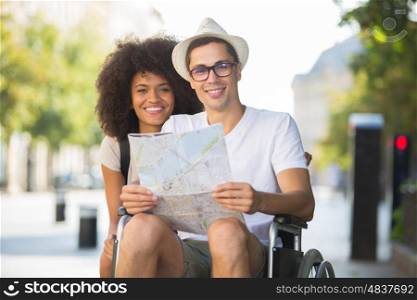 disabled man and girlfriend tourists consulting map of city
