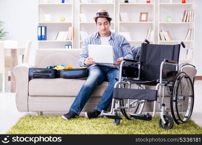 Disabled man booking travel online using laptop computer