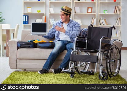 Disabled man booking travel online using laptop computer