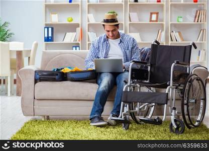 Disabled man booking travel online using laptop computer. The disabled man booking travel online using laptop computer