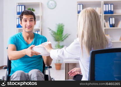 Disabled man in wheel chair visiting woman doctor