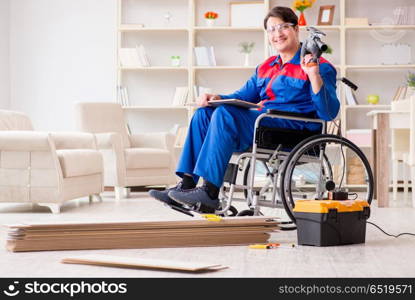 Disabled man laying floor laminate in office