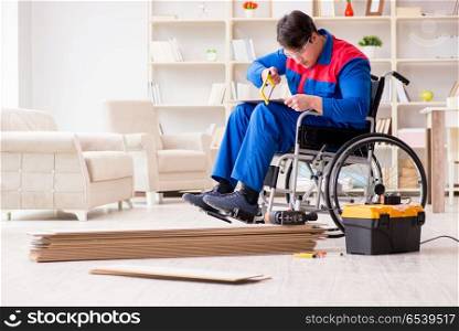 Disabled man laying floor laminate in office