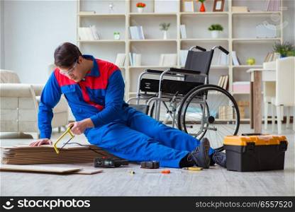 Disabled man laying floor laminate in office