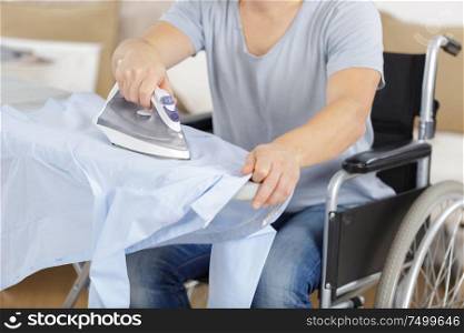 disabled man on wheelchair ironing clothing