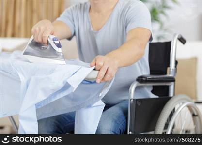disabled man on wheelchair ironing clothing