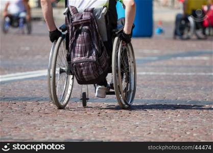 Disabled man rides in a wheelchair on the road