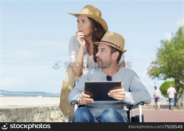 disabled man with his wife on the beach