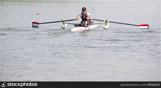 Disabled oarsman during the start of a stroke in a skiff