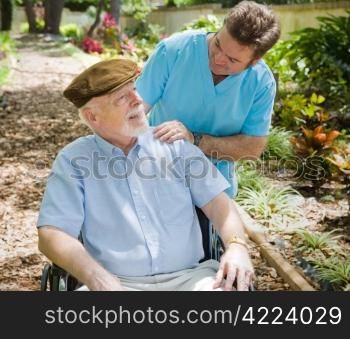 Disabled senior man in the garden with his male nurse.