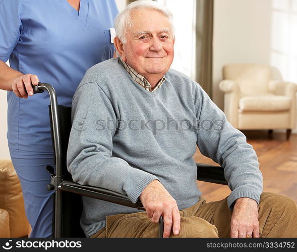 Disabled Senior Man Sitting In Wheelchair With Carer Behind