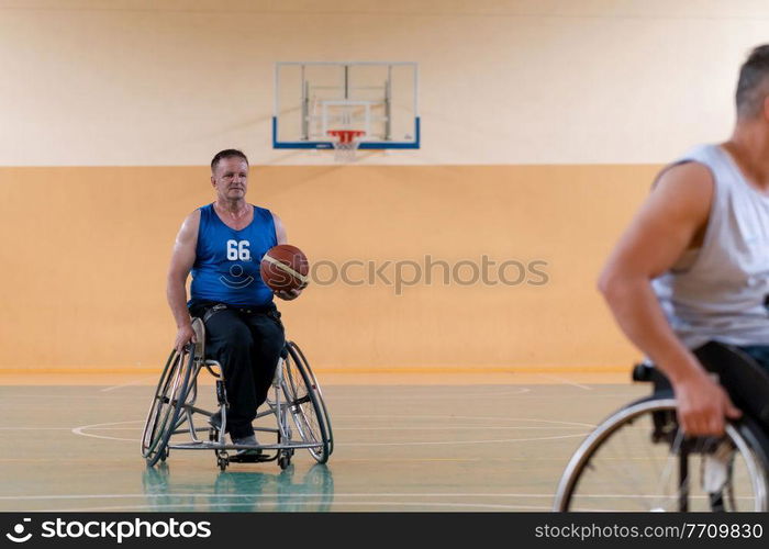 disabled war veterans in action while playing basketball on a basketball court with professional sports equipment for the disabled. High quality photo. disabled war veterans in action while playing basketball on a basketball court with professional sports equipment for the disabled