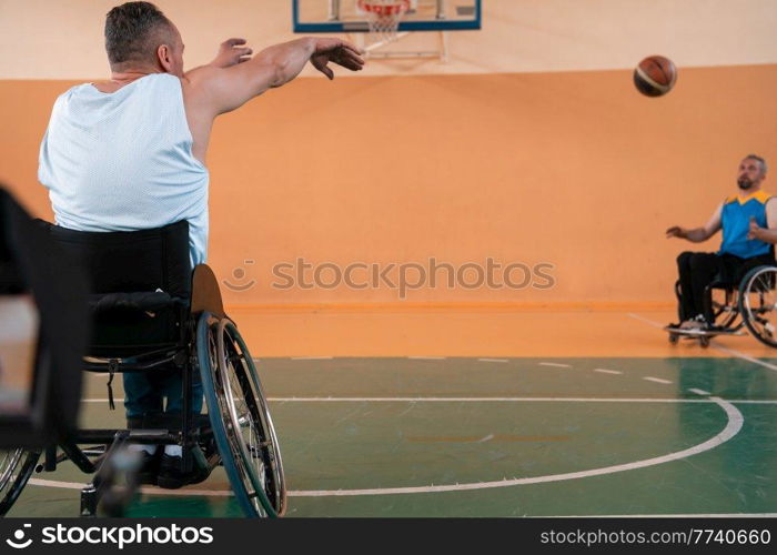 disabled war veterans in action while playing basketball on a basketball court with professional sports equipment for the disabled. High quality photo. Selective focus . disabled war veterans in action while playing basketball on a basketball court with professional sports equipment for the disabled