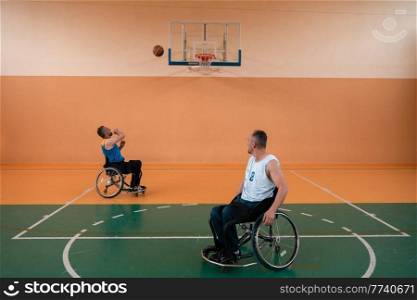 disabled war veterans in action while playing basketball on a basketball court with professional sports equipment for the disabled. High quality photo. Selective focus . disabled war veterans in action while playing basketball on a basketball court with professional sports equipment for the disabled
