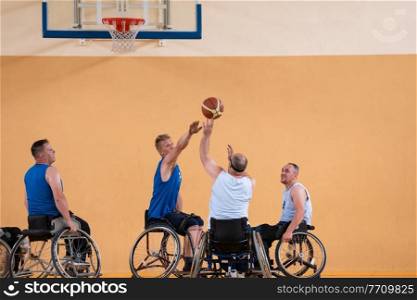 Disabled War veterans mixed race opposing basketball teams in wheelchairs photographed in action while playing an important match in a modern hall. High quality photo. Disabled War veterans mixed race opposing basketball teams in wheelchairs photographed in action while playing an important match in a modern hall. 