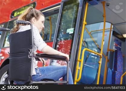 Disabled Woman In Wheelchair Boarding Bus