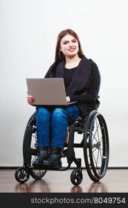 Disabled woman with laptop on wheelchair.. Technology and mobile equipment. Disabled handicapped girl with laptop computer. Young woman business worker on wheelchair.