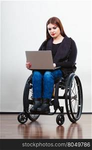 Disabled woman with laptop on wheelchair.. Technology and mobile equipment. Disabled handicapped girl with laptop computer. Young woman business worker on wheelchair.
