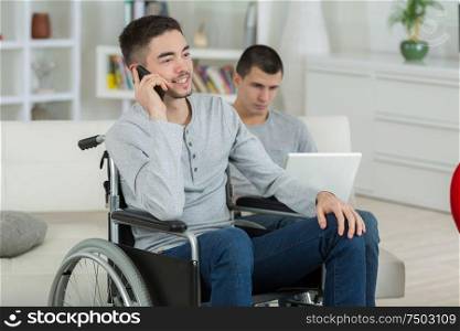 disabled young man talking on the phone at home