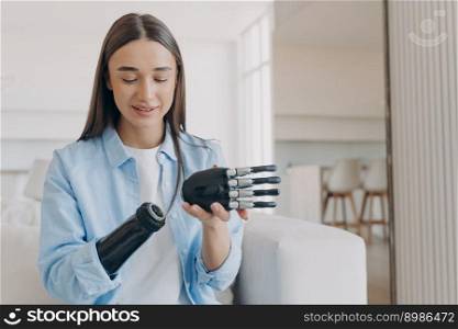 Disabled young woman is assembling bionic arm with hand. Prosthesis is connecting in wrist joint. Cyber sensor hand has processor chip and buttons. European girl has high tech carbon electronic hand.. Disabled young woman is assembling bionic arm with hand. Prosthesis is connecting in wrist joint.