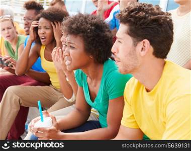 Disappointed Spectators In Team Colors Watching Sports Event
