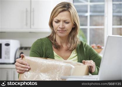 Disappointed Woman Unpacking Online Purchase At Home